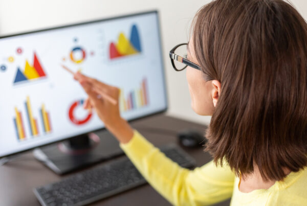 Femme analysant des graphiques sur un écran, représentant la formation en gestion de données.